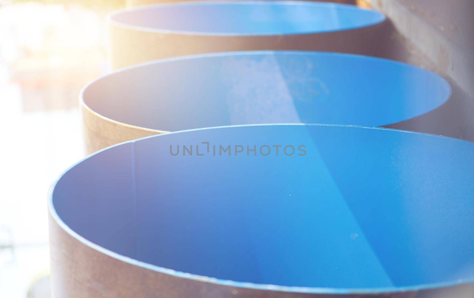 blue construction big pipe before install with sun flare ,vertical