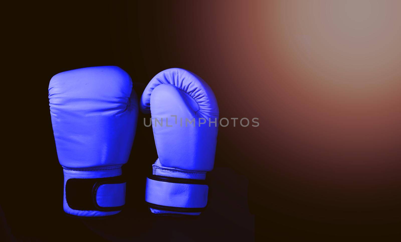 Blue boxing gloves in sport on black