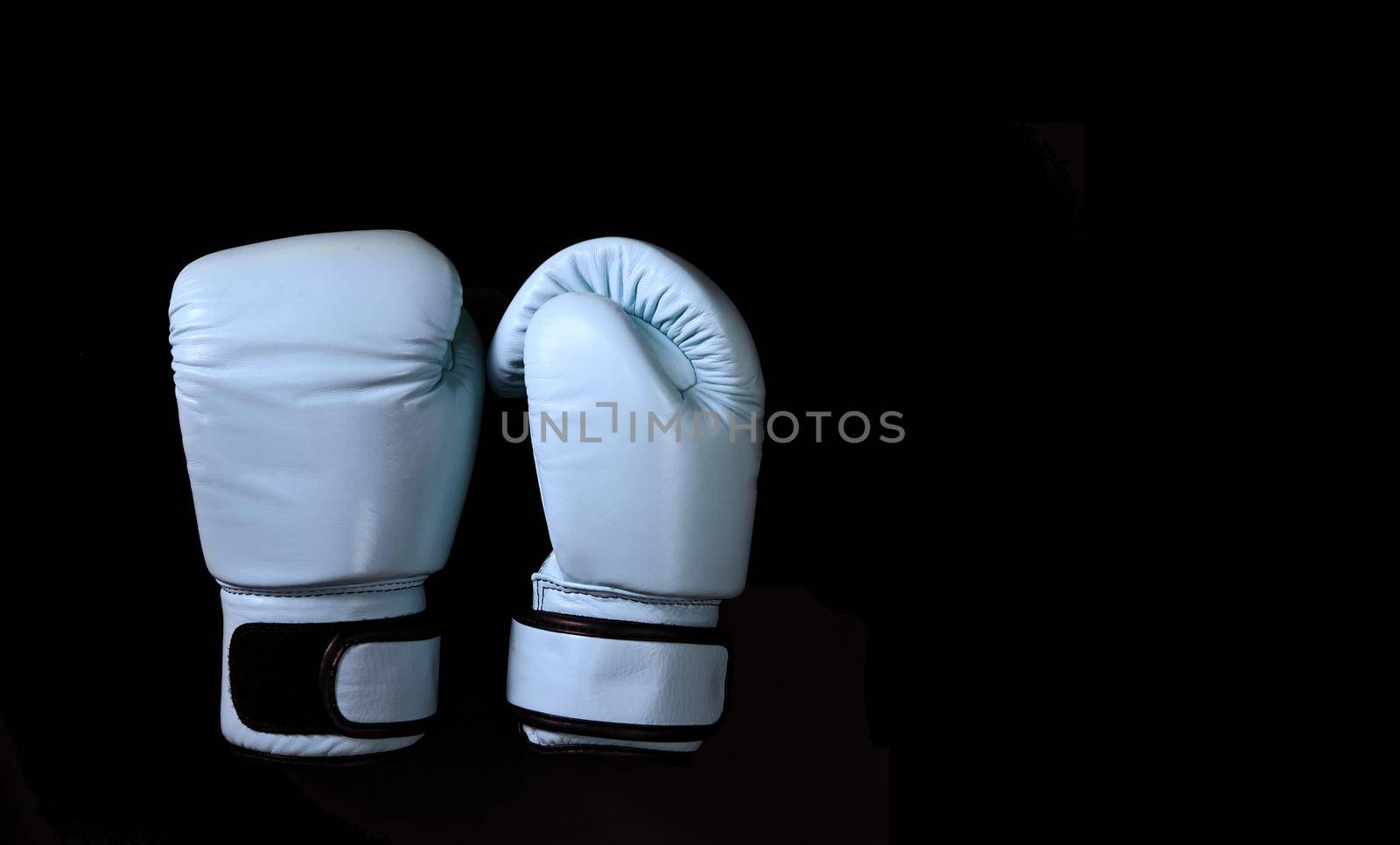 Blue boxing gloves in sport on black