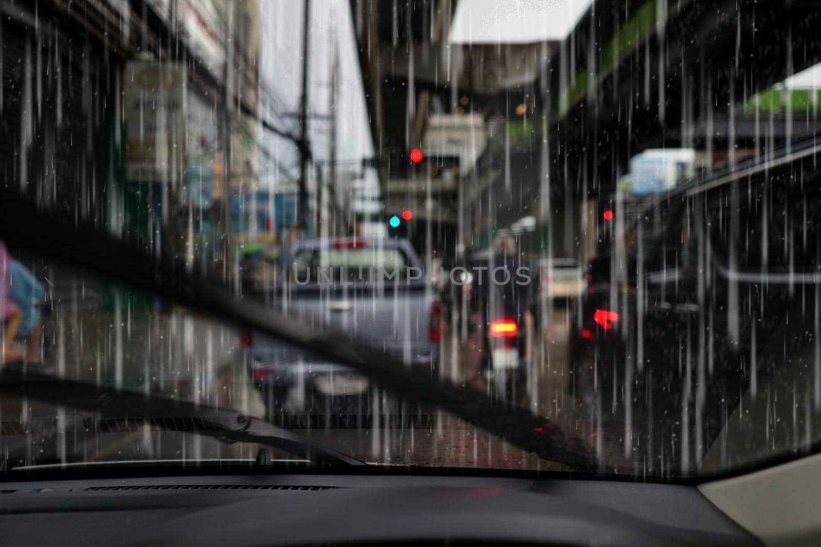 city rain view from wind shield of car in urban weather