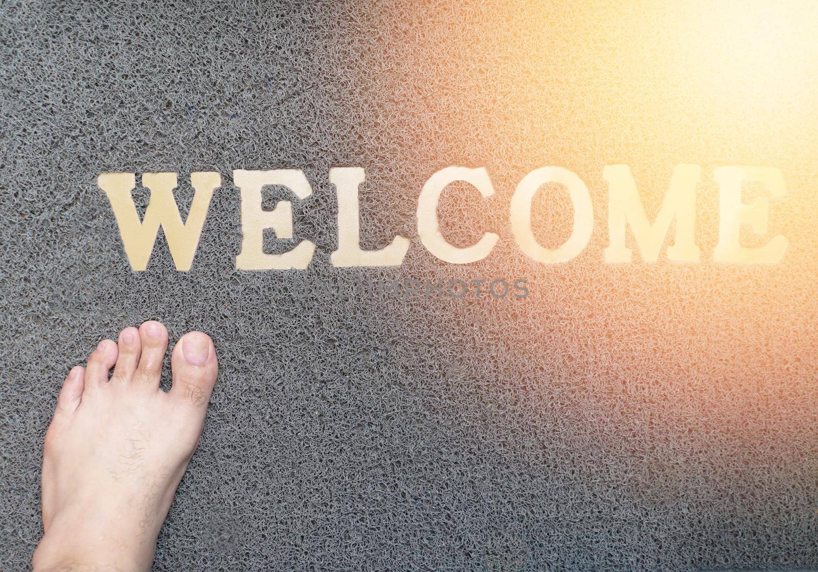 bare foot with welcome mat with sun