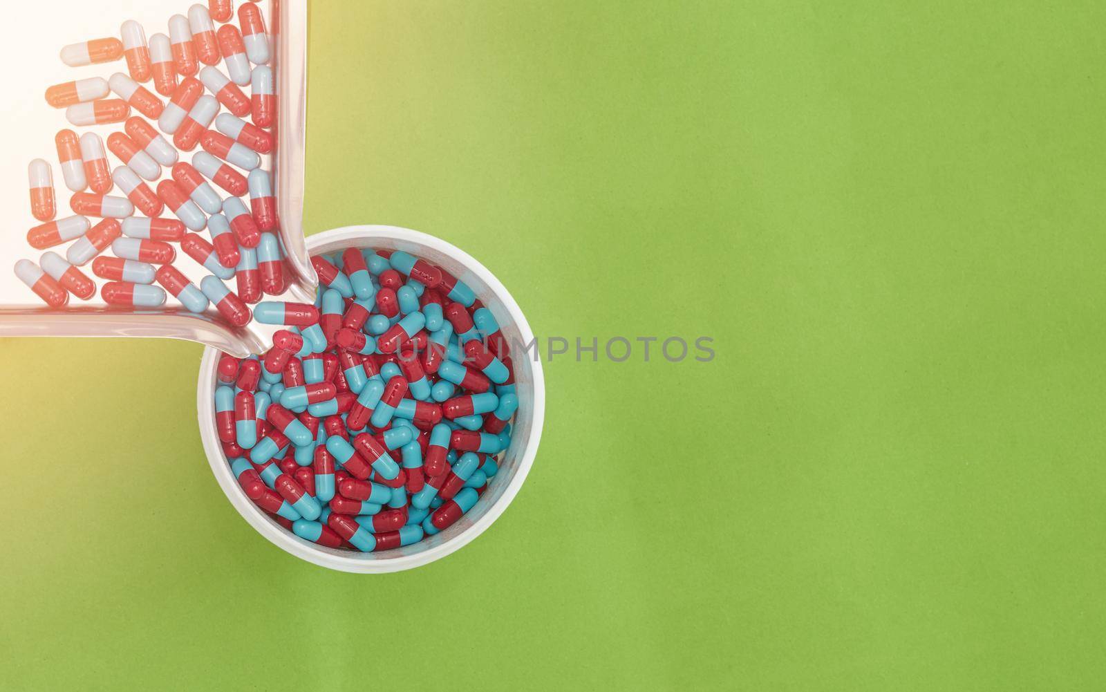 pouring pills on tray on color background