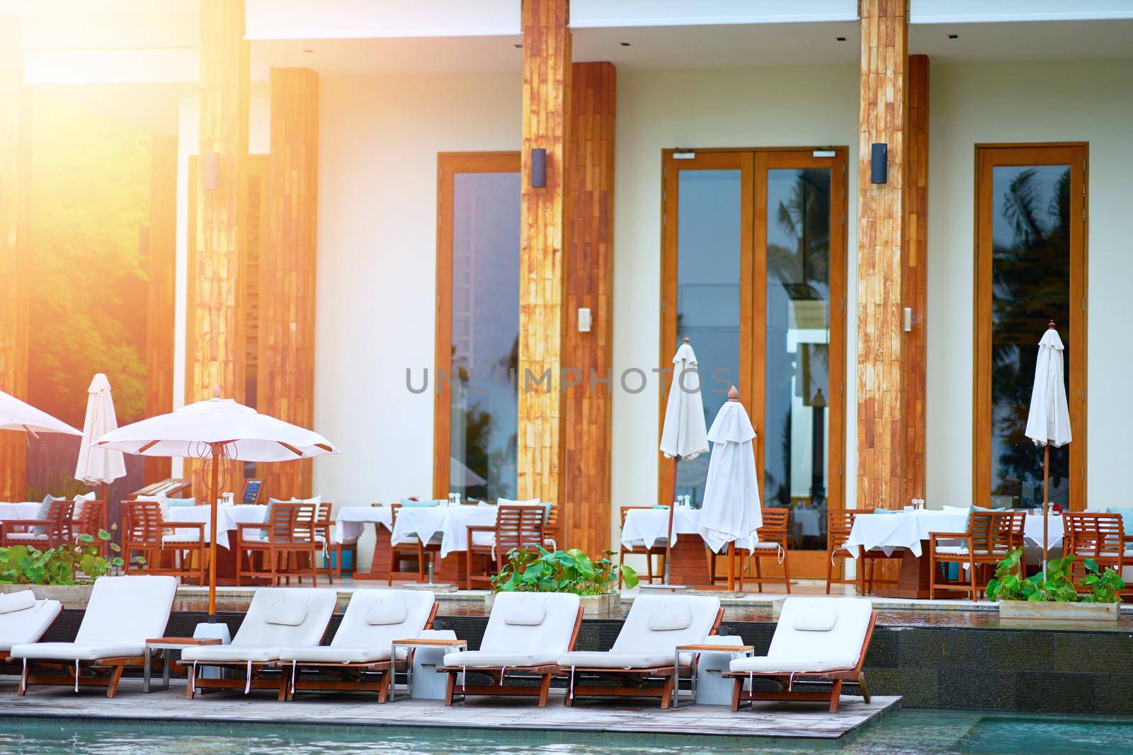 Beach front of hotel in day time and crouch and umbrella