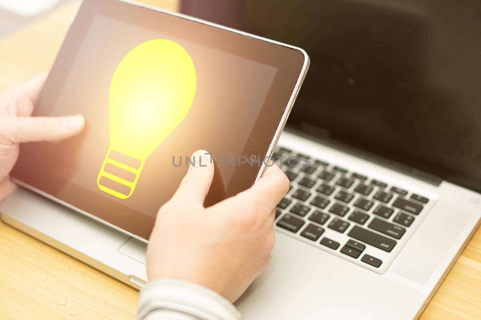 hand hold tablet with light bulb idea illumination in business technology