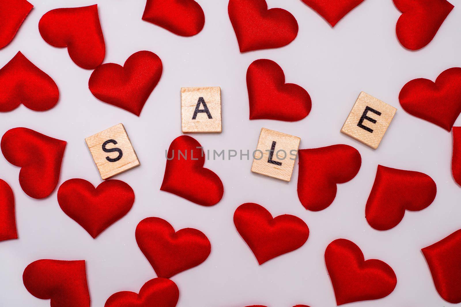 Sale inscription, a lot of red hearts on a white background. by Matiunina