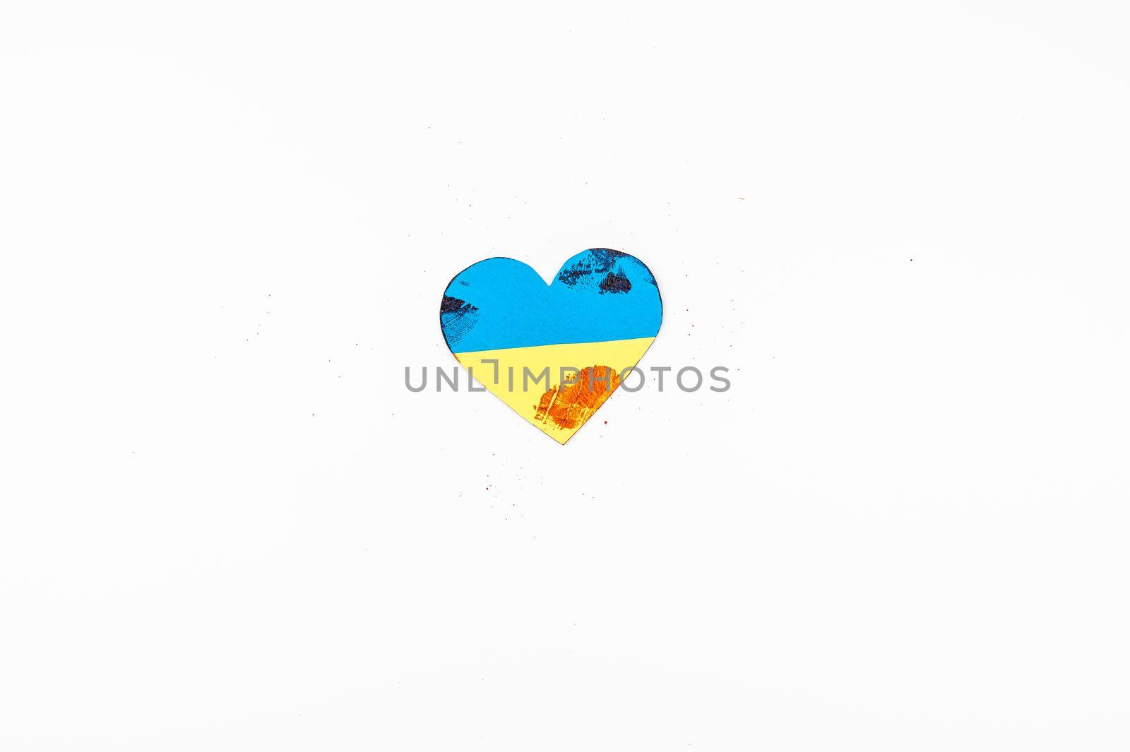 Heart with the flag of Ukraine is smeared with blood on a white background