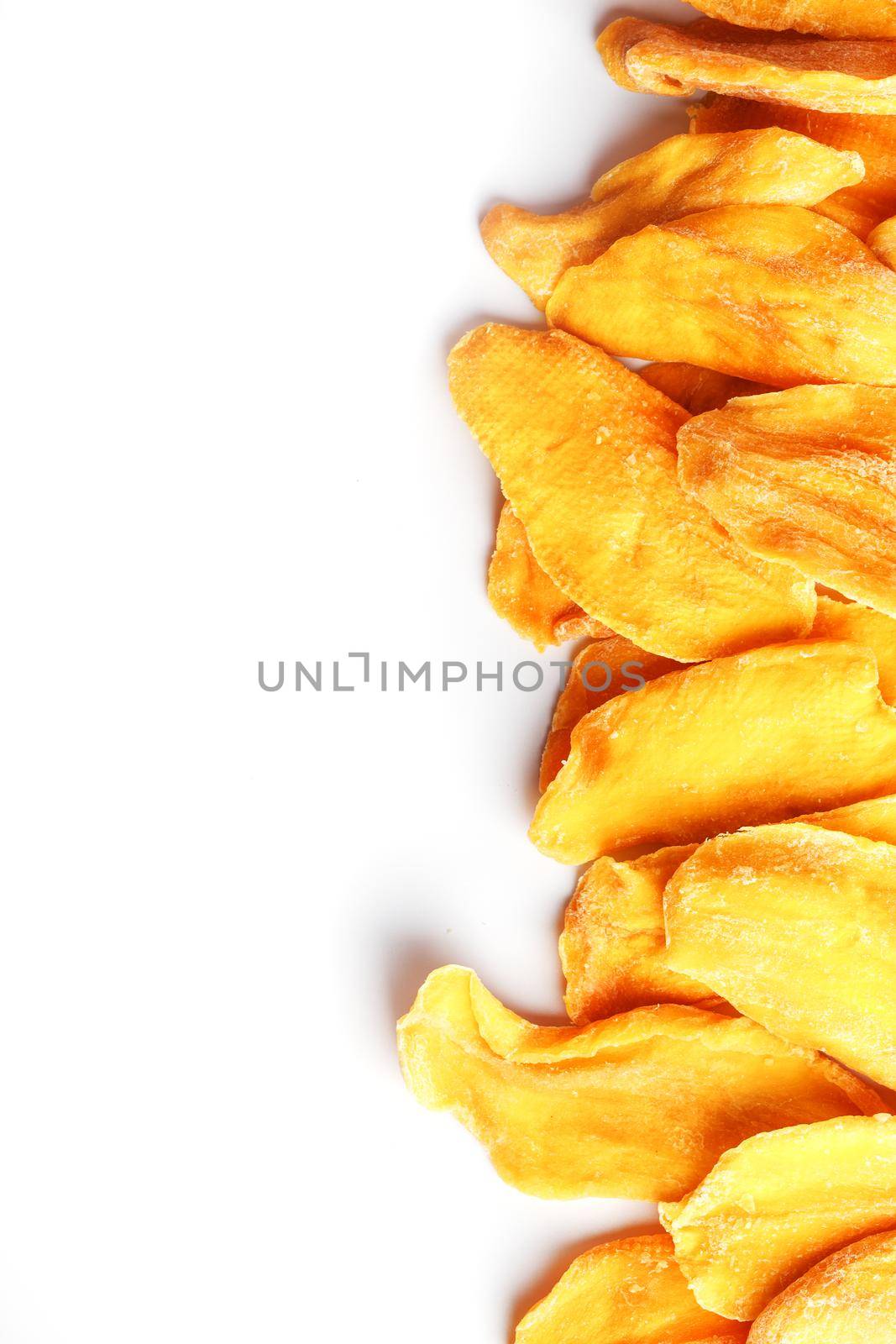 Dried mango sliced on a white background with free space by AlexGrec