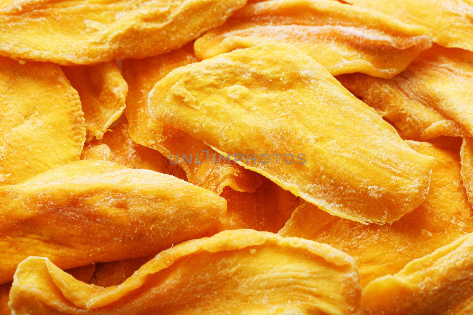 Pieces of sweet dried mango close-up as a background in full screen top view