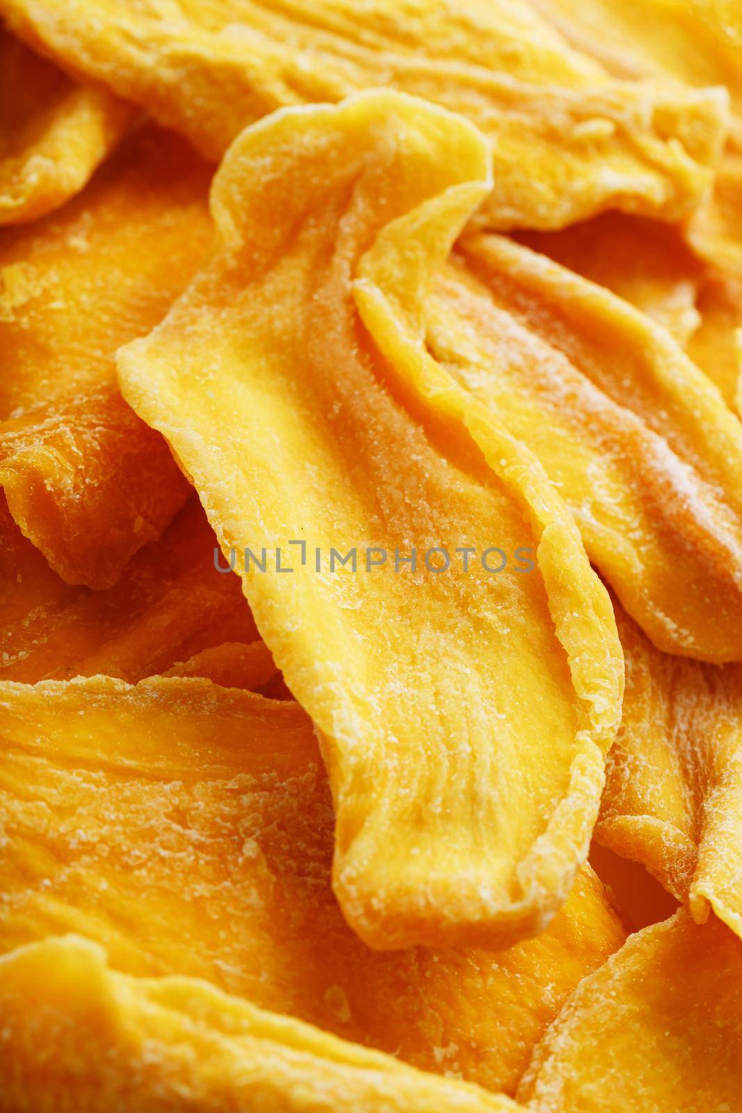 Pieces of sweet dried mango close-up as a background in full screen by AlexGrec