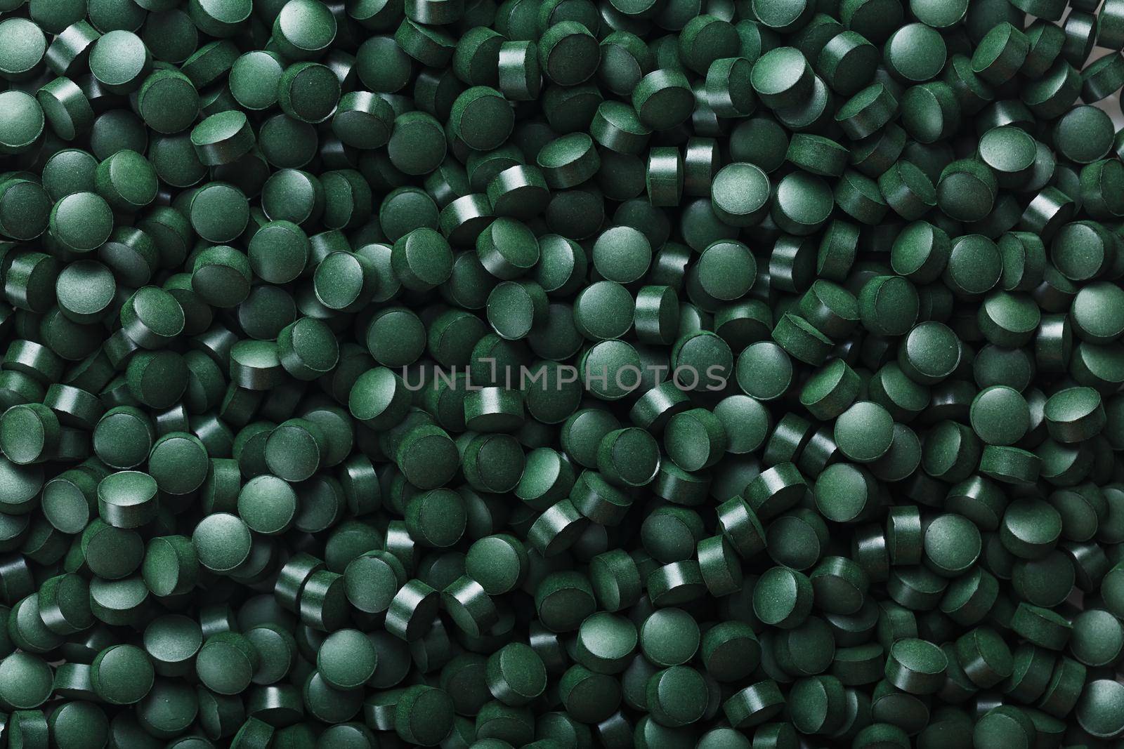 Green tablets from spirulina vegetarian dietary supplement as a full-screen texture