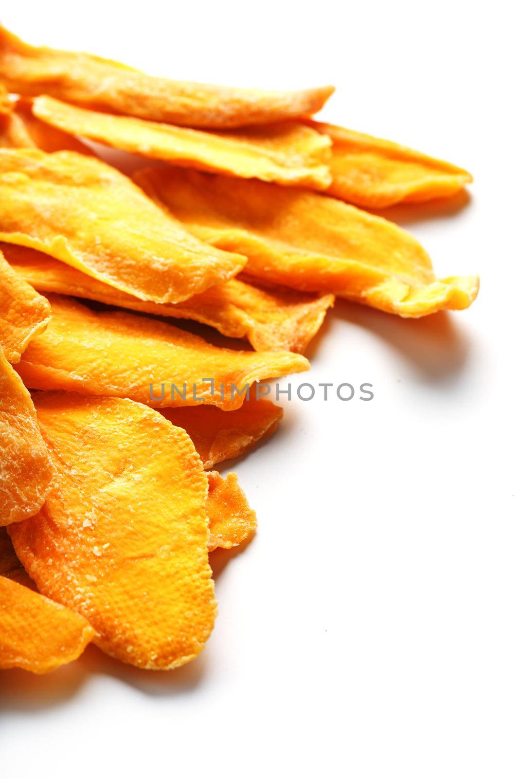 Dried mango sliced on a white background with free space by AlexGrec