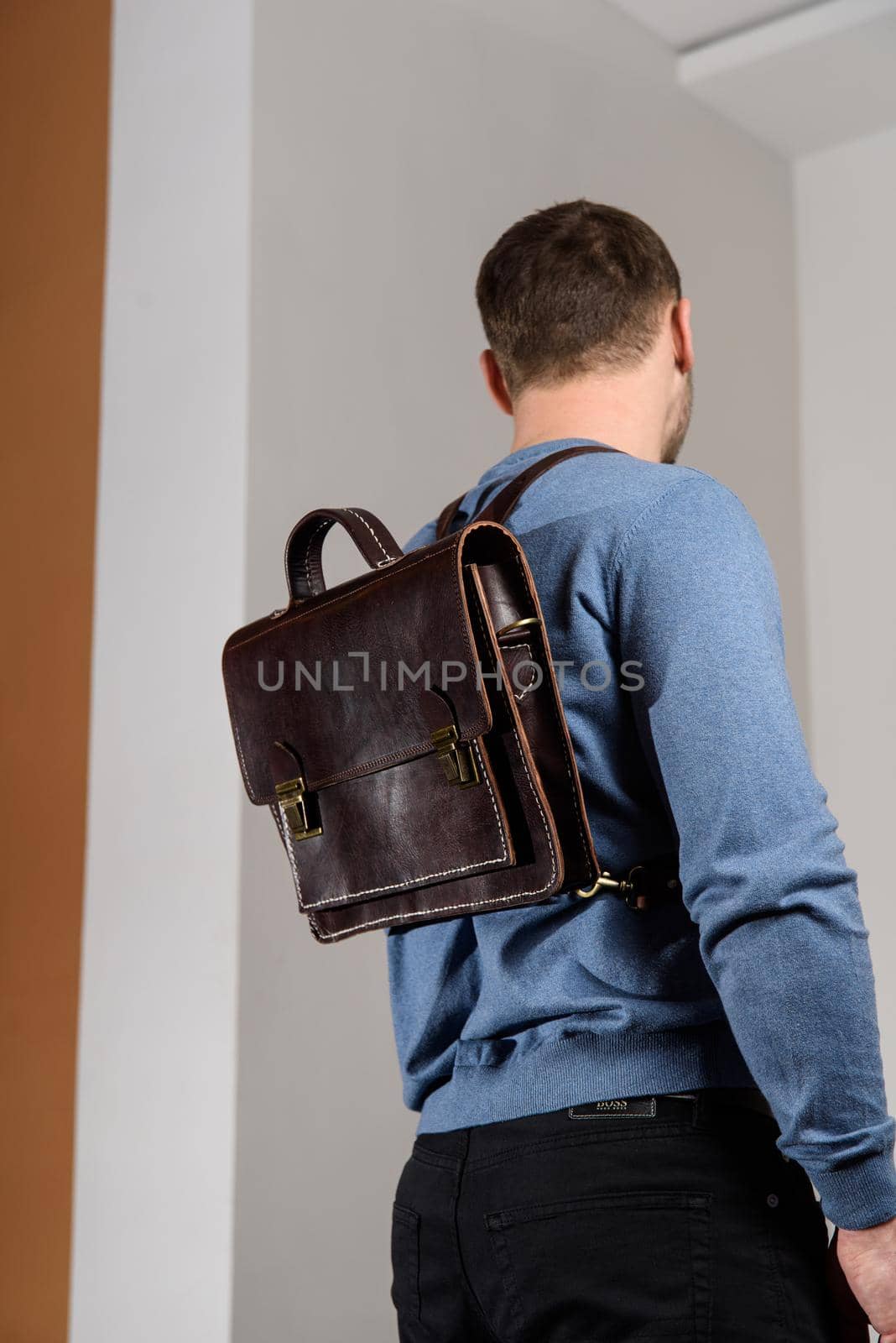 Back of man in a blue sweater with brown leather backpack. Unisex bag for sale. by Ashtray25