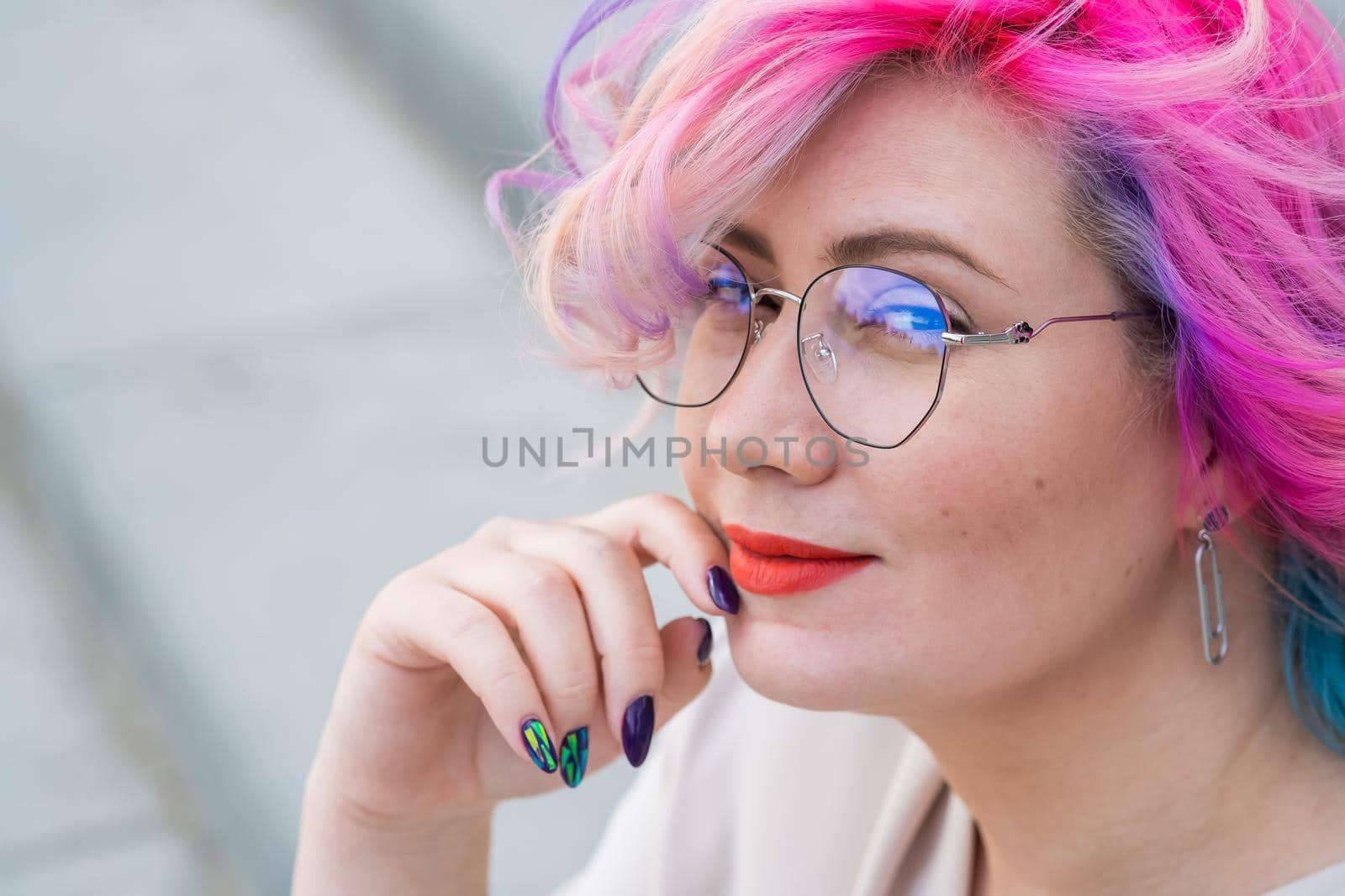 Close-up portrait of curly Caucasian woman with multi-colored hair. Model for hairstyles.