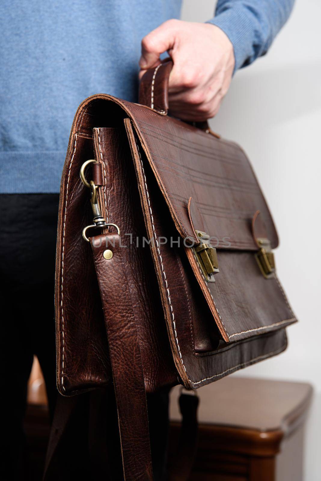 Man holding brown leather briefcase with two locks. hotel room photo by Ashtray25