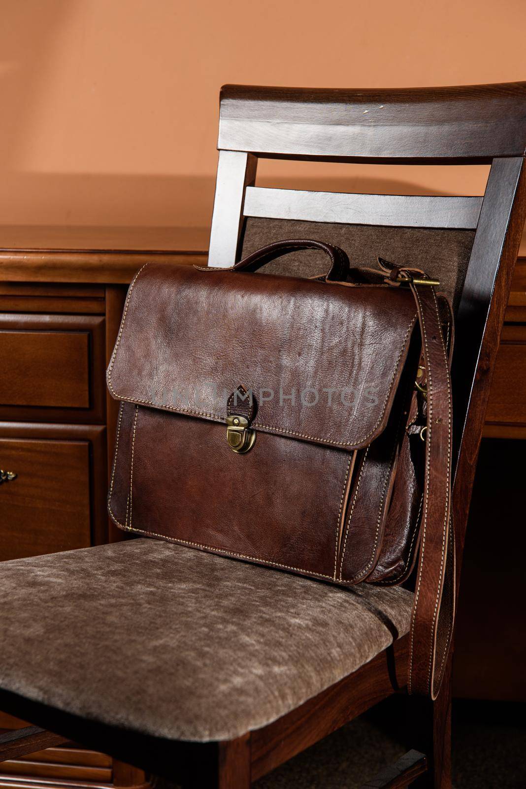 brown leather briefcase with antique and retro look for man on a chair. Hotel room photo by Ashtray25