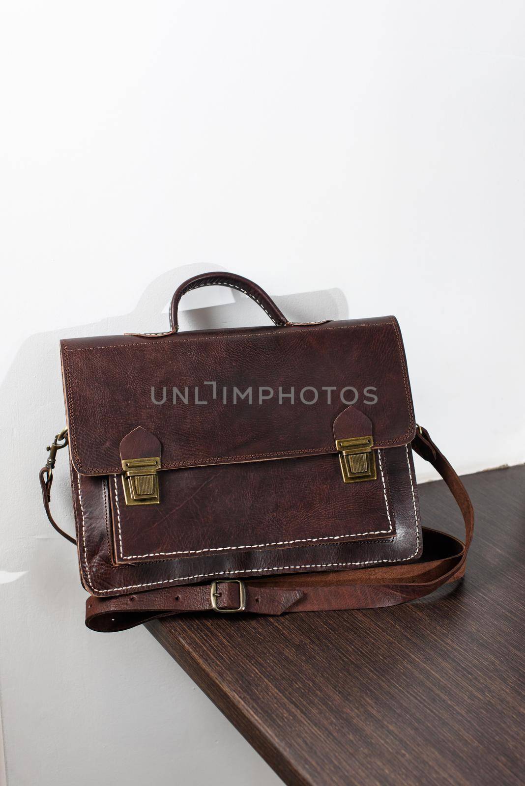 brown leather briefcase with antique and retro looks for man. indoor photo