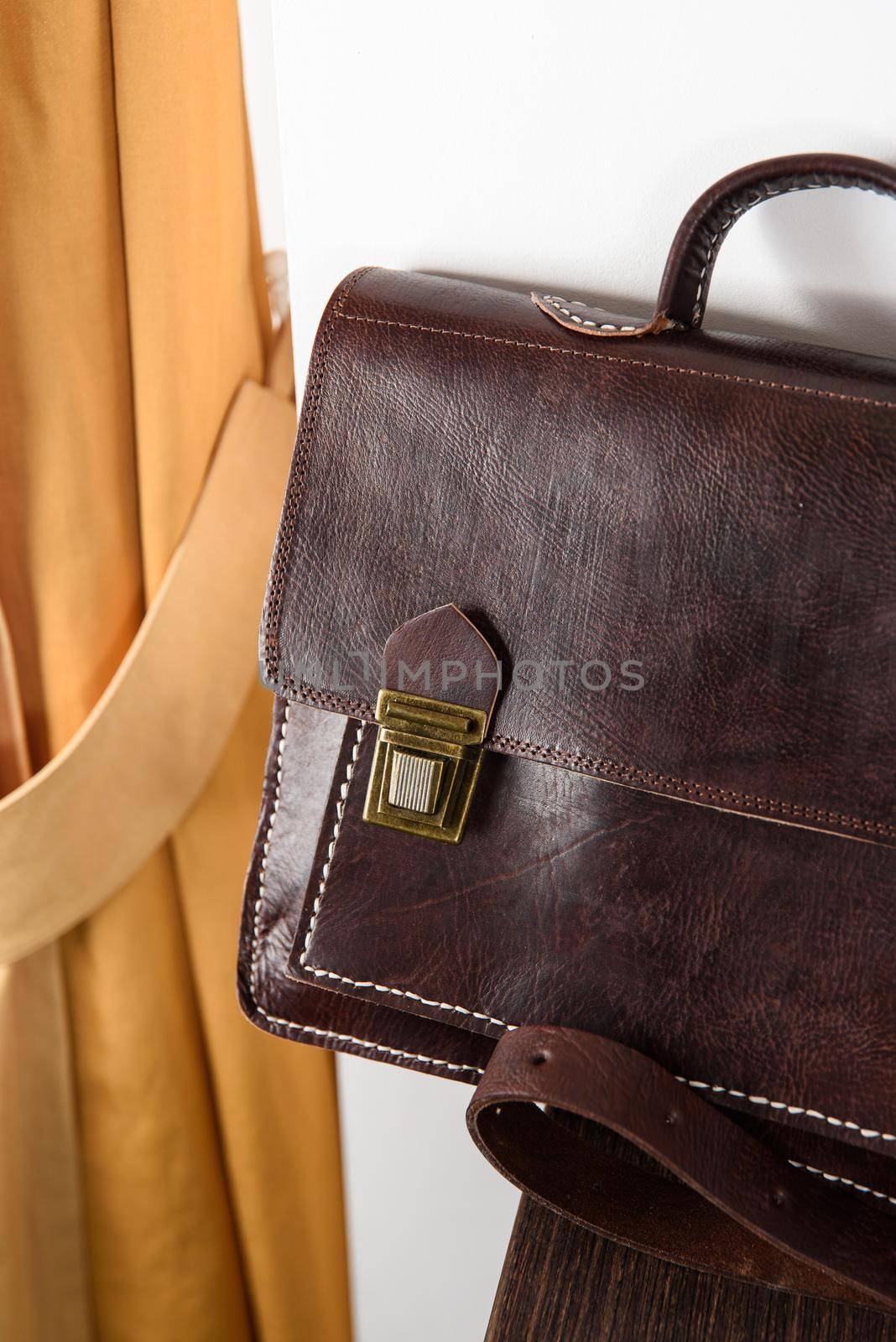 brown leather briefcase with antique and retro looks for man. indoor photo