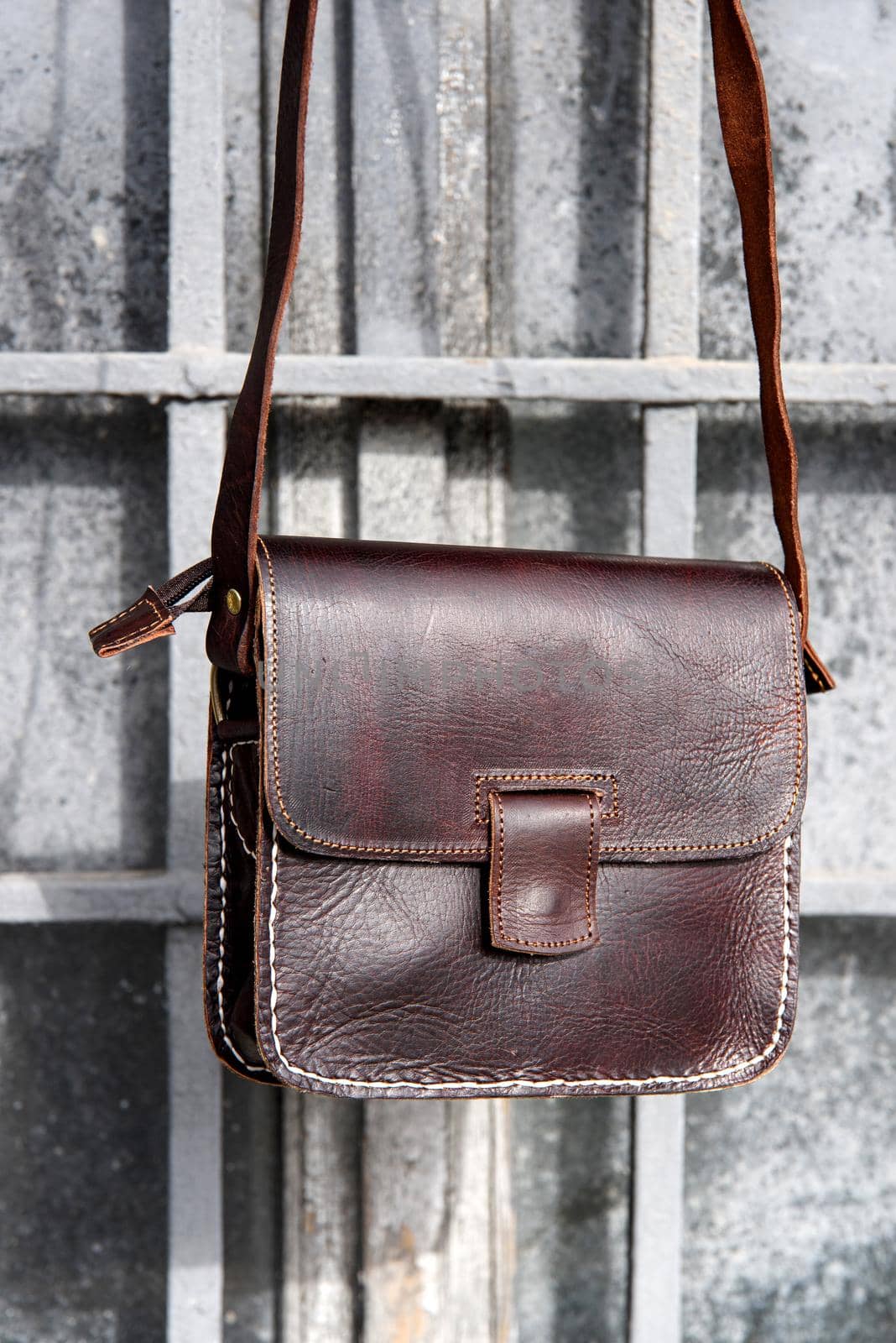 close-up photo of brown leather messanger bag. outdoors photo.