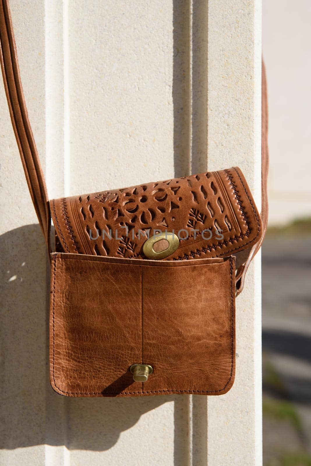 small yellow women's leather bag with a carved pattern. street photo