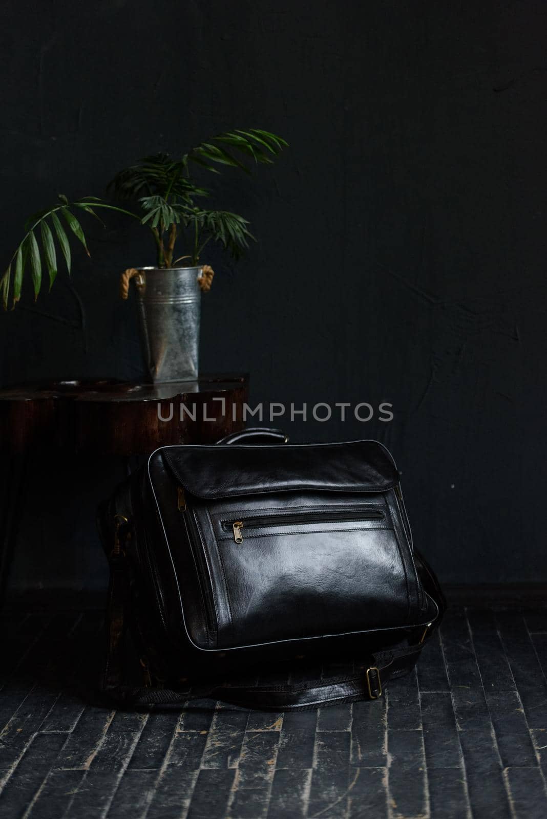 Leather black travel bag, on a black wooden floor by Ashtray25