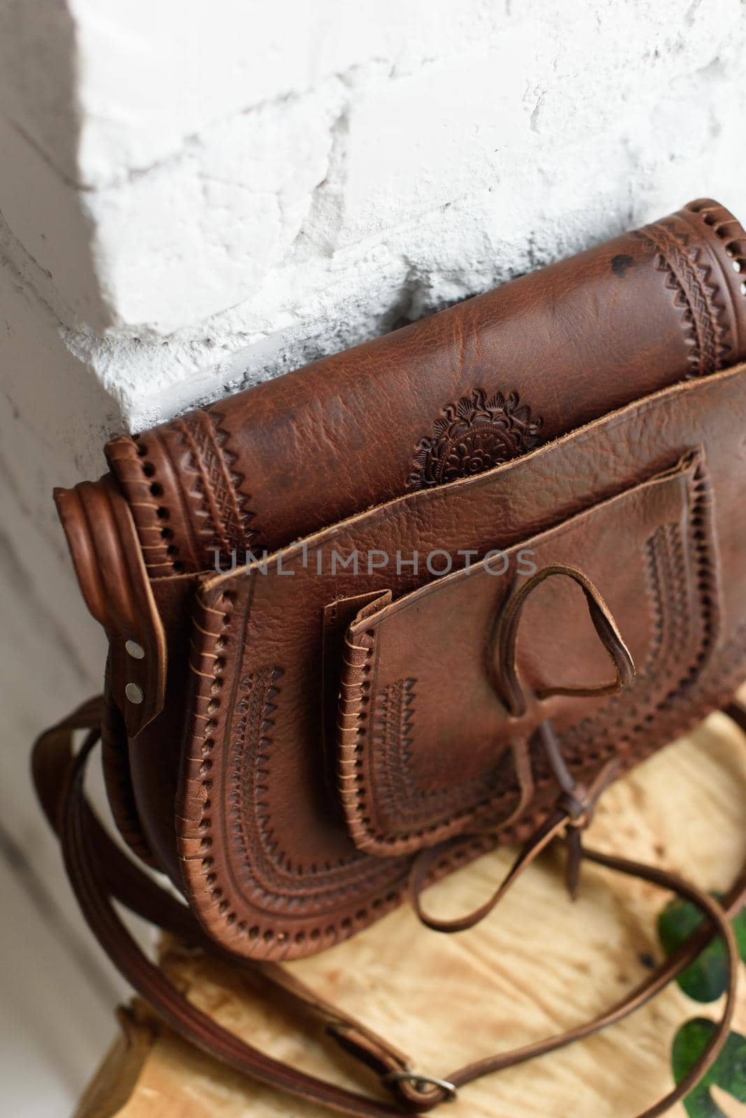 small brown women's leather bag with a carved pattern. selective focus by Ashtray25