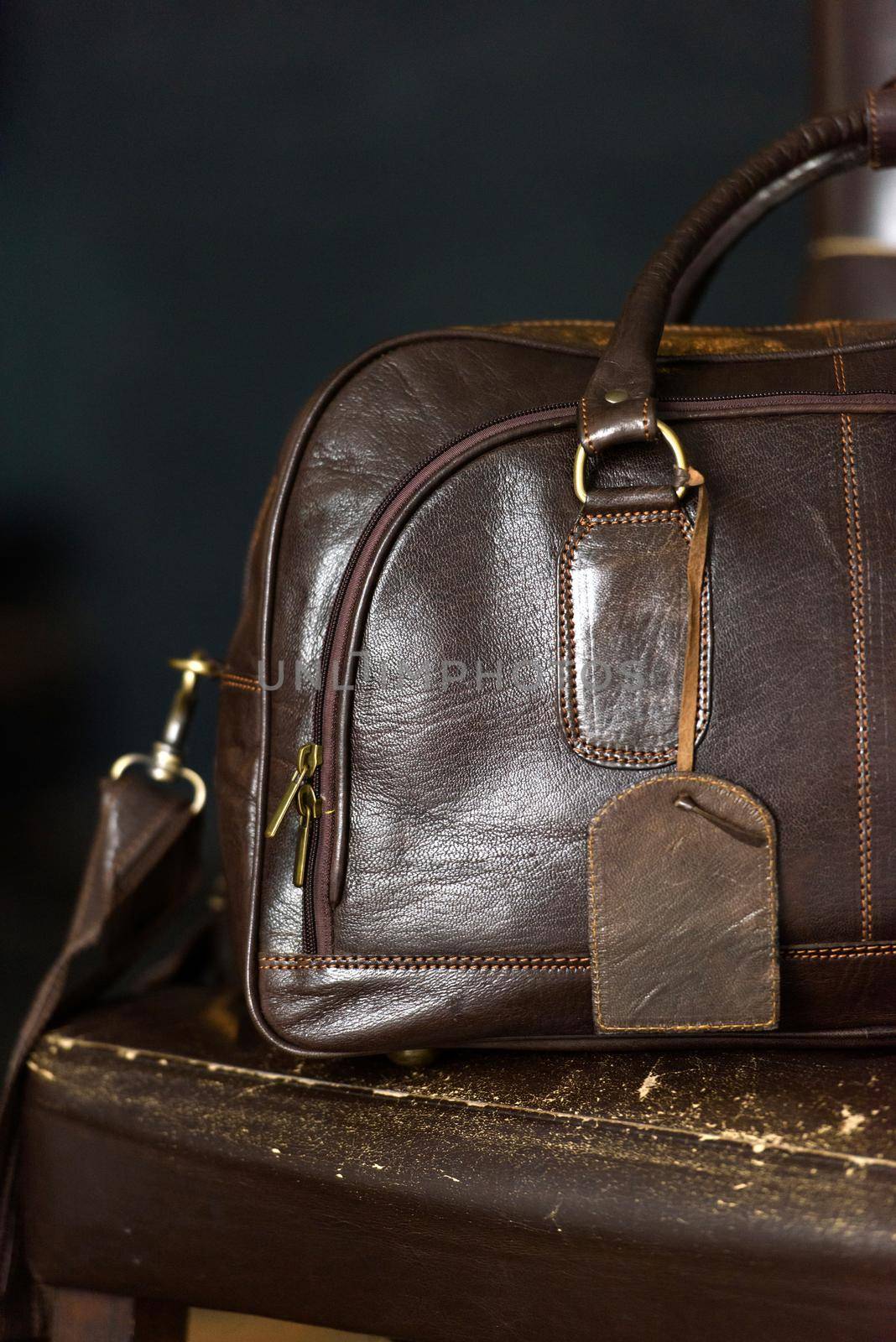 Leather brown travel bag, on a brown leather chair by Ashtray25