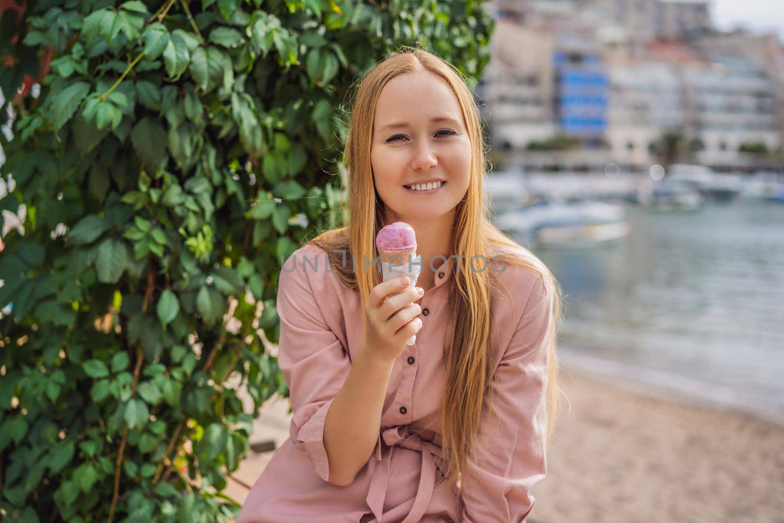 Close up of pretty tourist girl eating traditional gelato italian ice cream in a European town by galitskaya