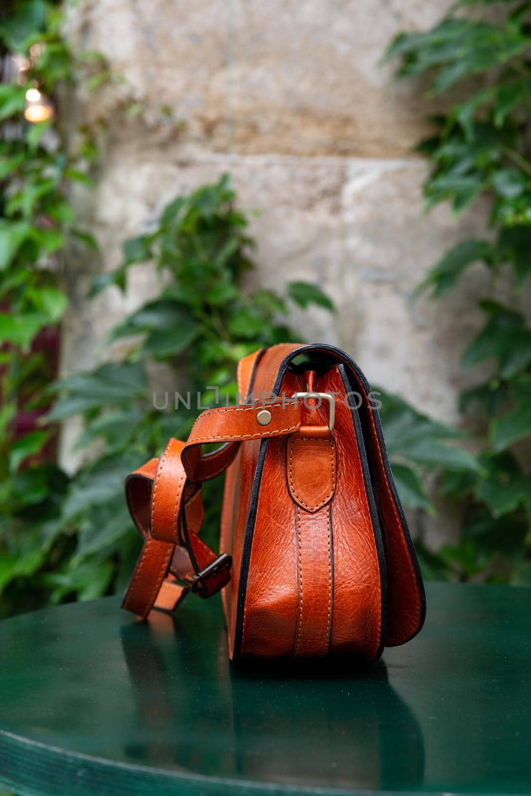 small orange women's leather bag on a green table by Ashtray25