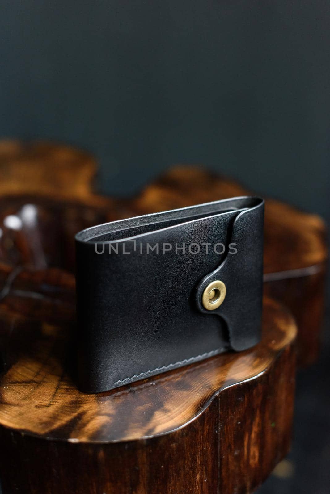 hand made black leather wallet on a wood . Leather craft. Selective focus by Ashtray25