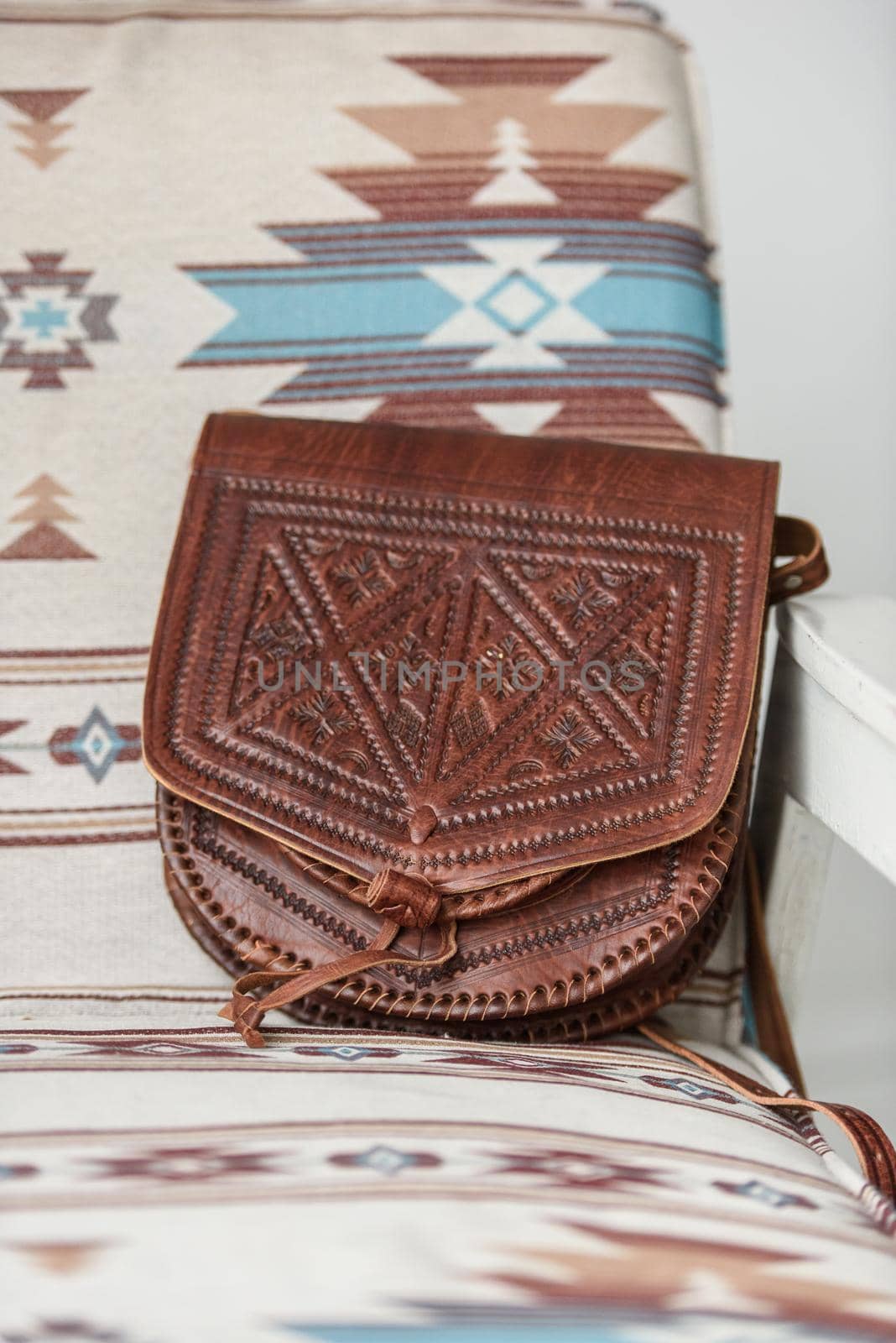 small brown women's leather bag with a carved pattern. indoor photo