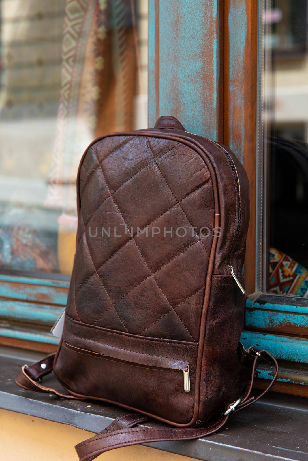 Brown leather backpack on the windowsill. outdoors photo by Ashtray25