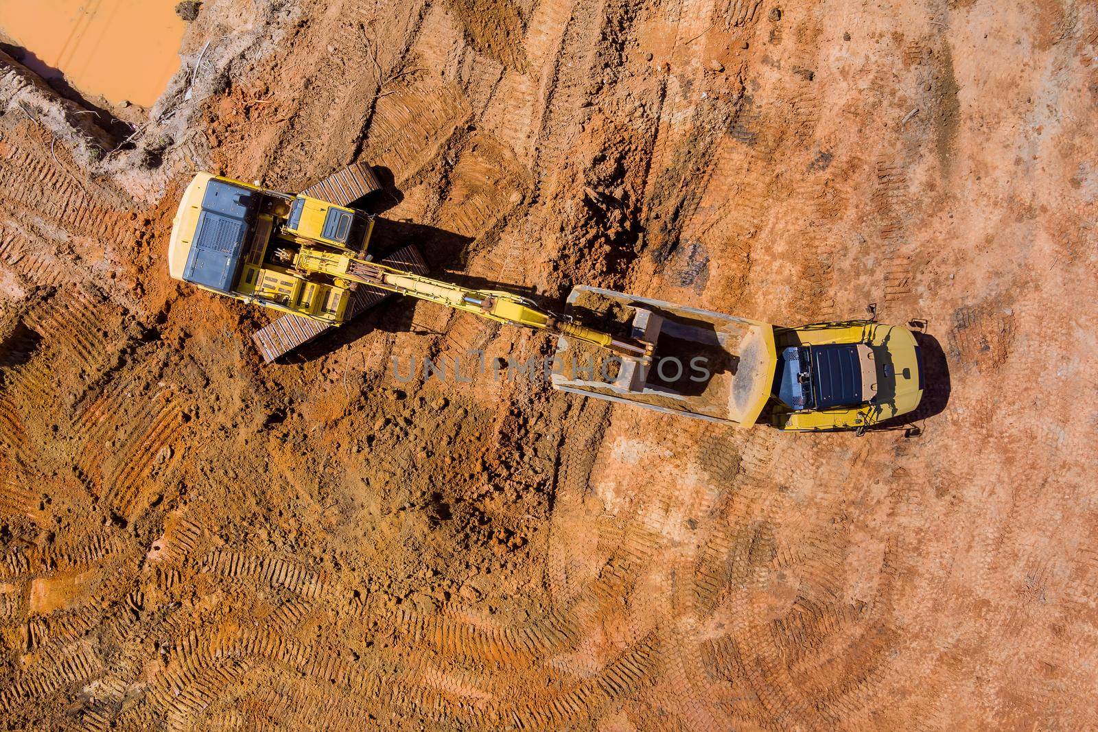 Top aerial view of excavator truck are loading soil a dump truck