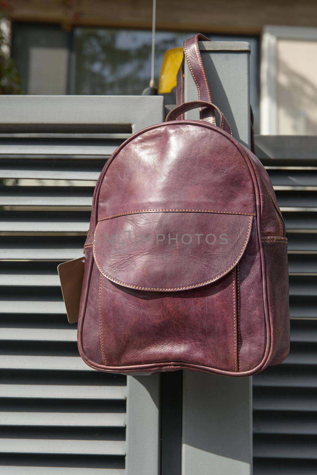 burgundy leather backpack on the metal fence by Ashtray25