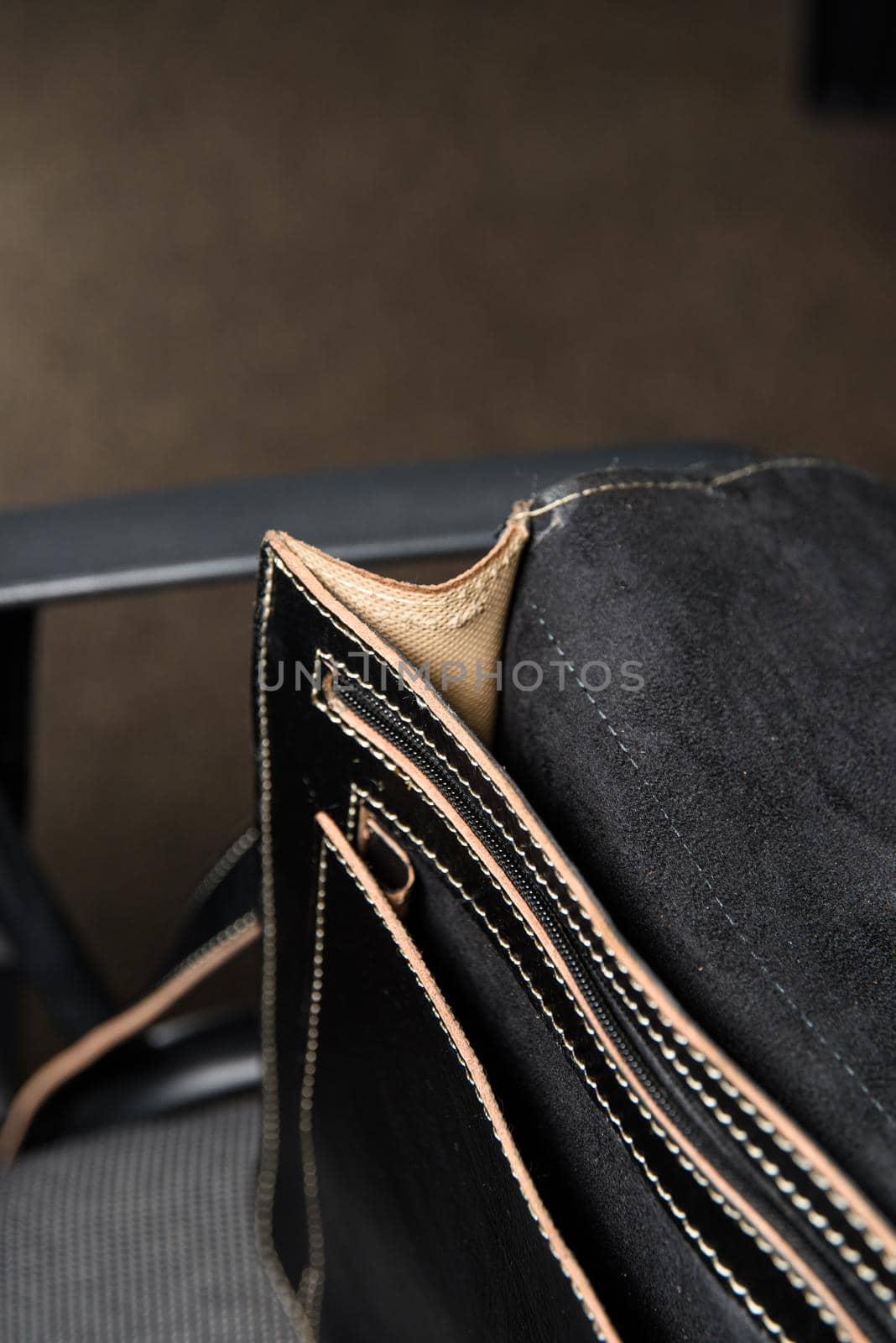 Open black leather briefcase with antique and retro look for man on a office chair.