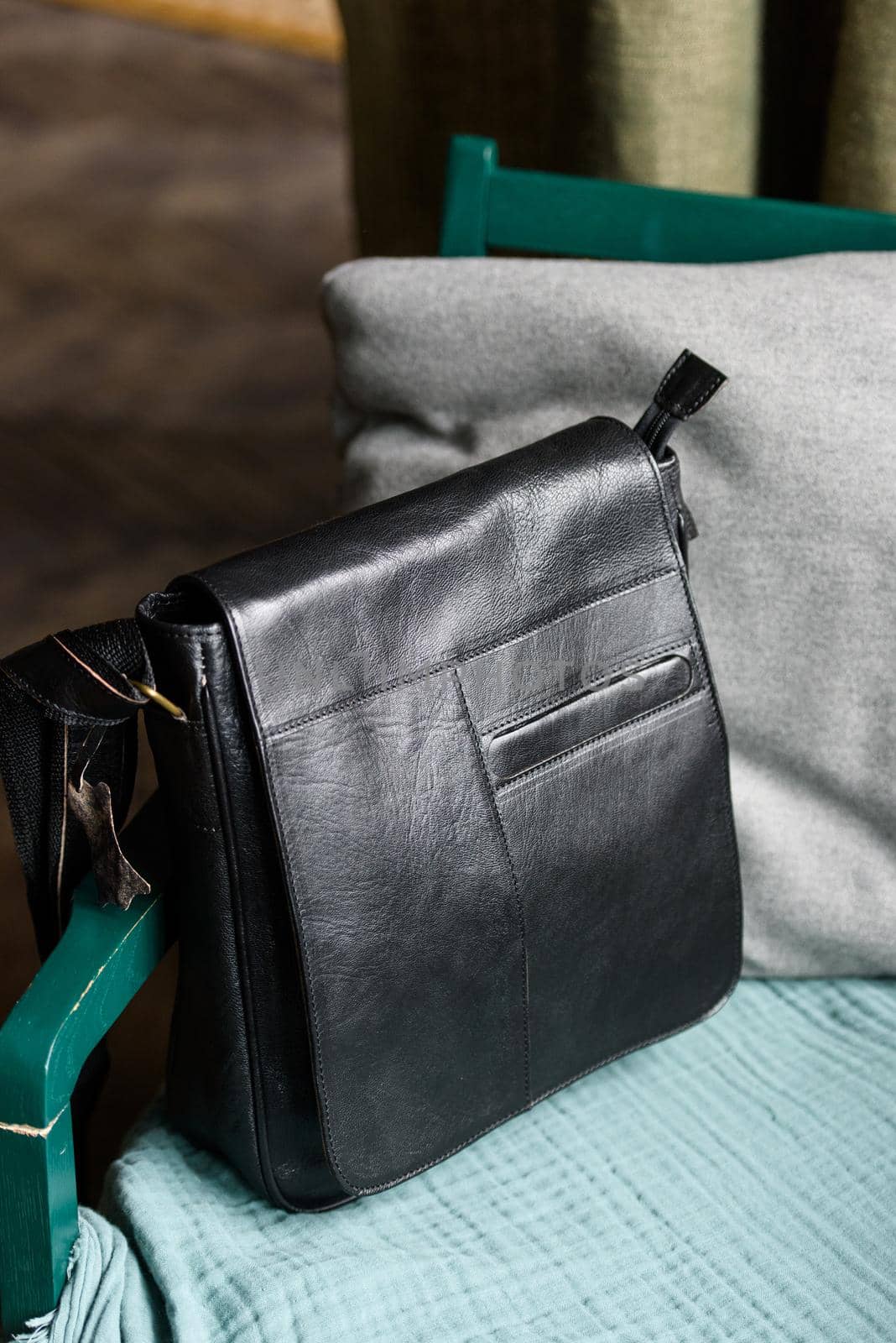 close-up photo of black messanger leather bag on a chair. indoor photo