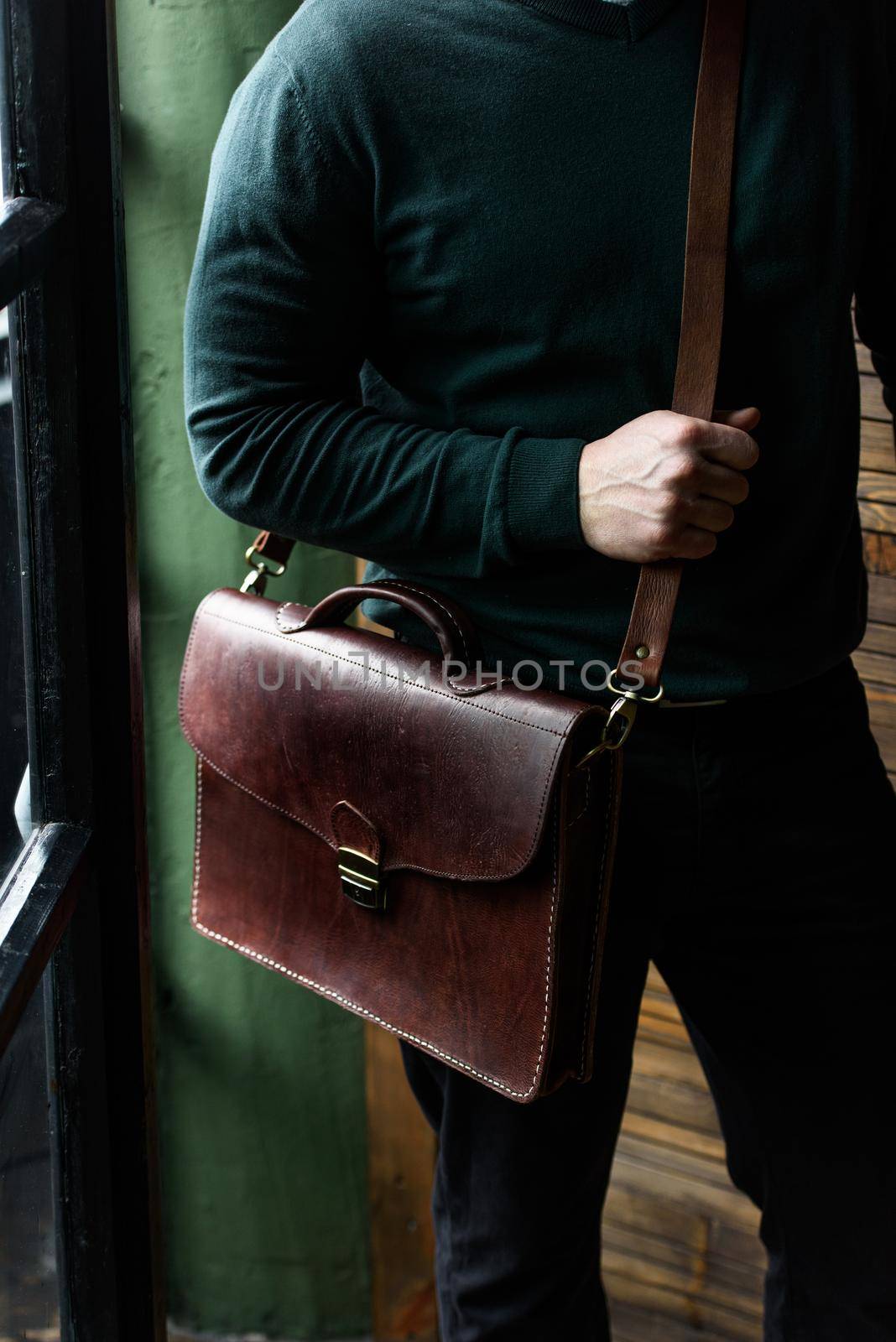 close-up photo of brown leather bag in mans hands by Ashtray25