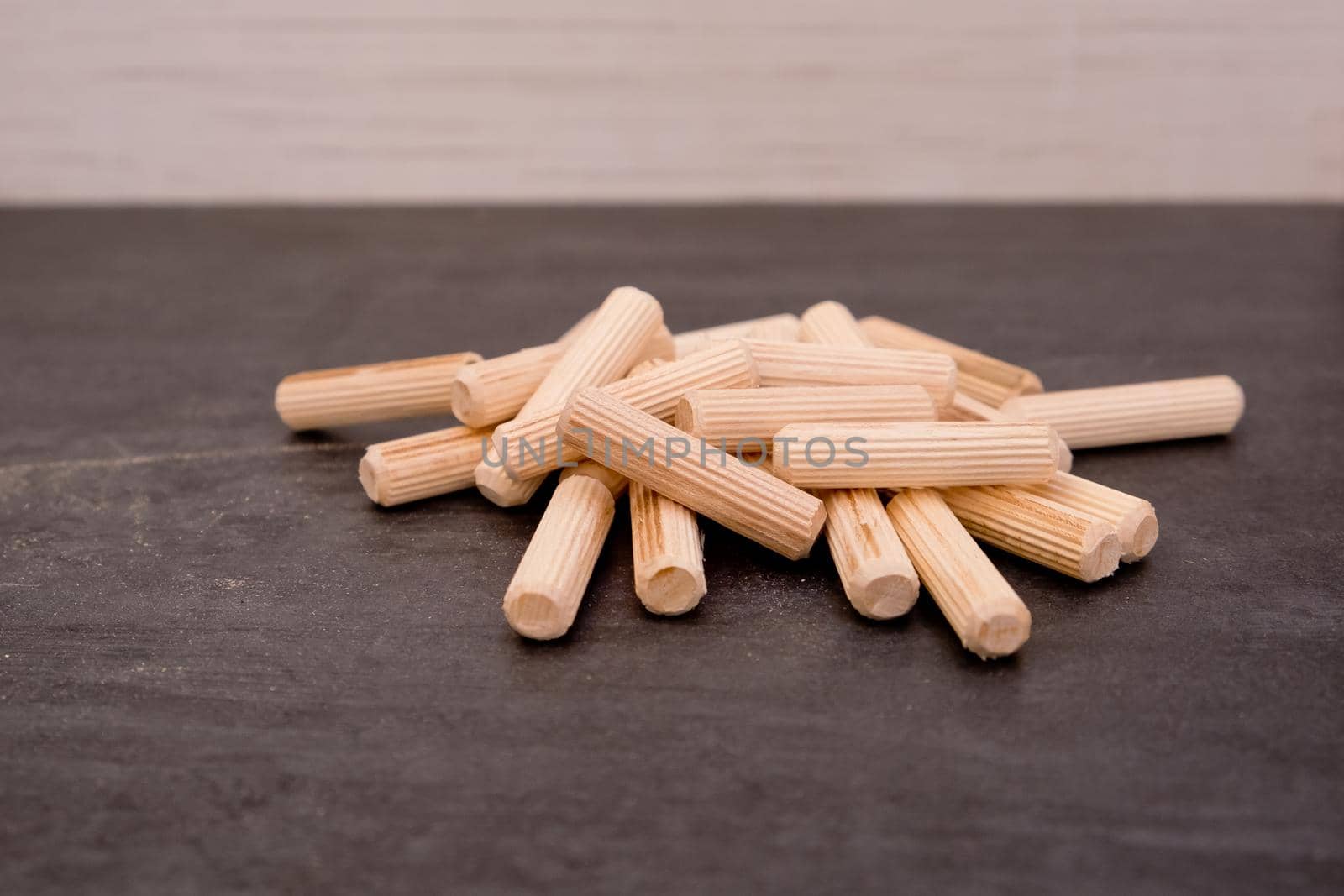 View of a grouping of wooden dowels on grey background. Close-up.