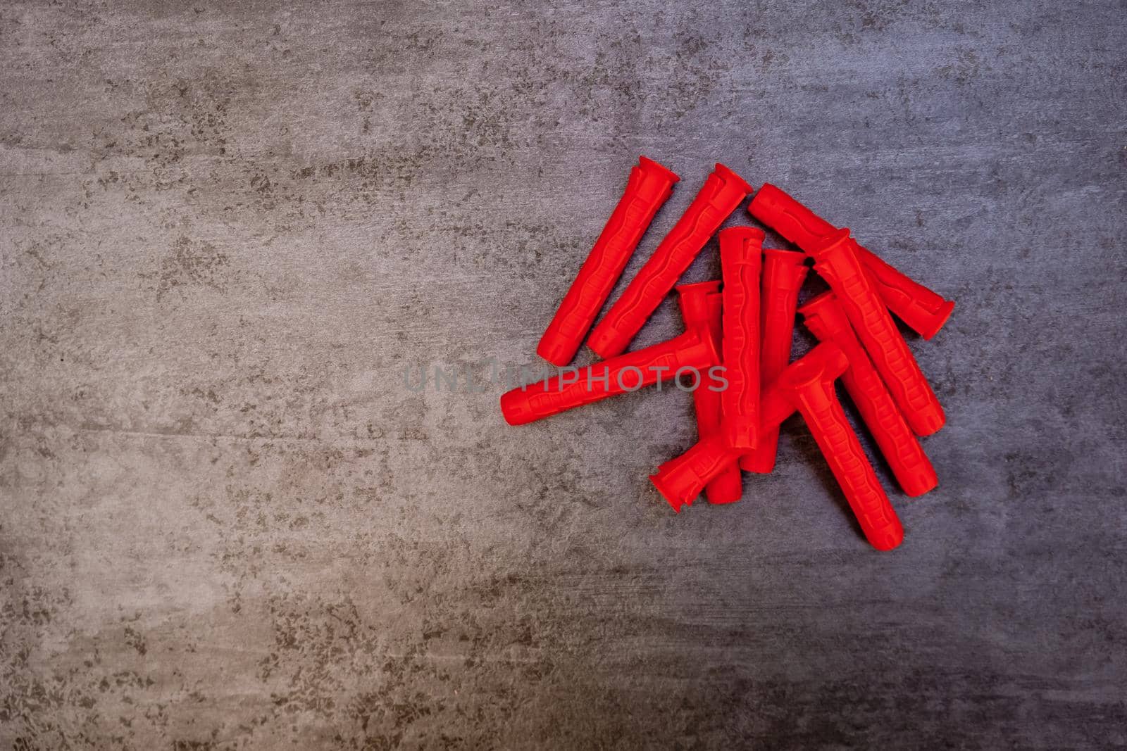 Red plastic dowels on grey background.