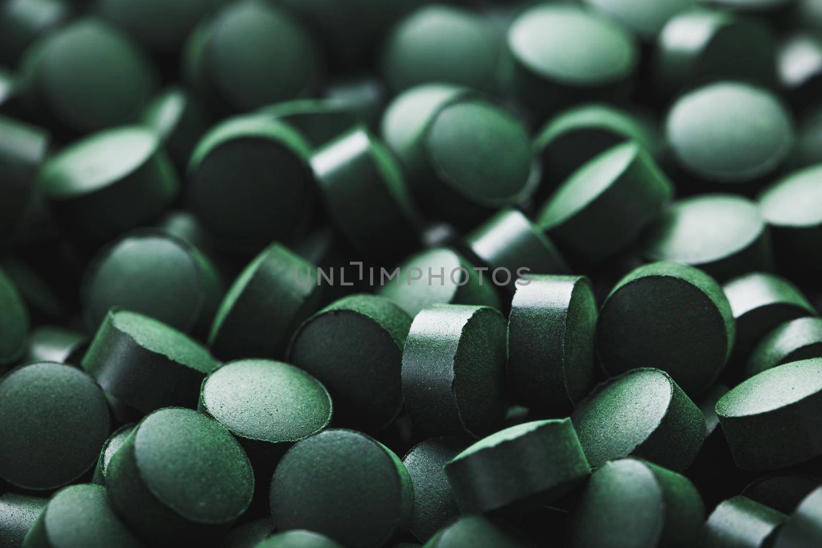 Close-up of Green tablets of organic spirulina as a texture background macro in full screen