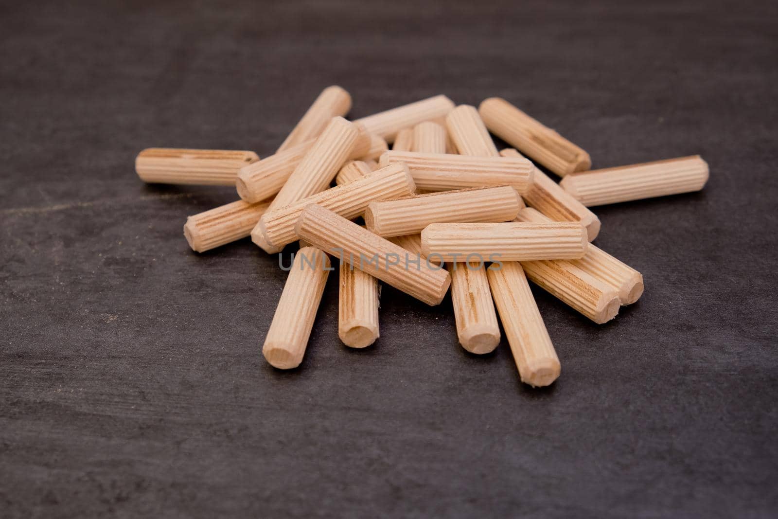 View of a grouping of wooden dowels on grey background. Close-up. by leonik