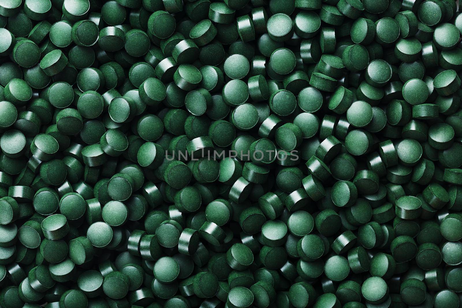 Green tablets from spirulina vegetarian dietary supplement as a full-screen texture