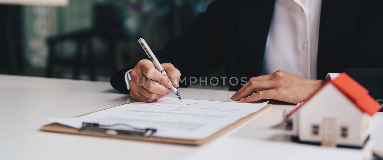 Businessman working doing finances and calculation cost of real estate investment while be signing to contract, Concept mortgage loan approval by nateemee