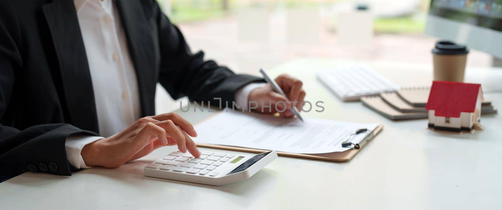 Business woman working doing finances and calculation cost of real estate investment while be signing to contract, Concept mortgage loan approval