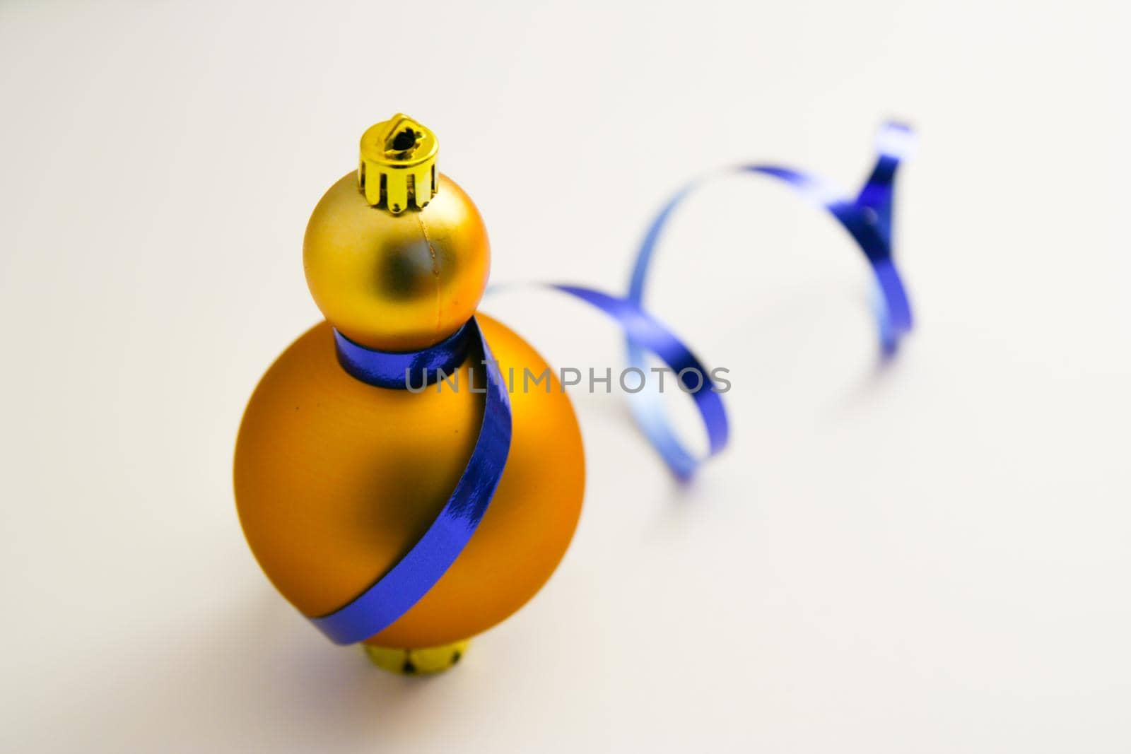 Golden christmas decoration balls with blue ribbon bow isolated on white background
