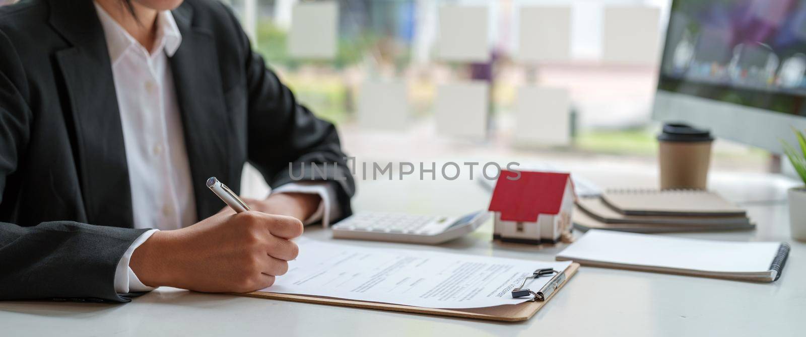 Business woman working doing finances and calculation cost of real estate investment while be signing to contract, Concept mortgage loan approval