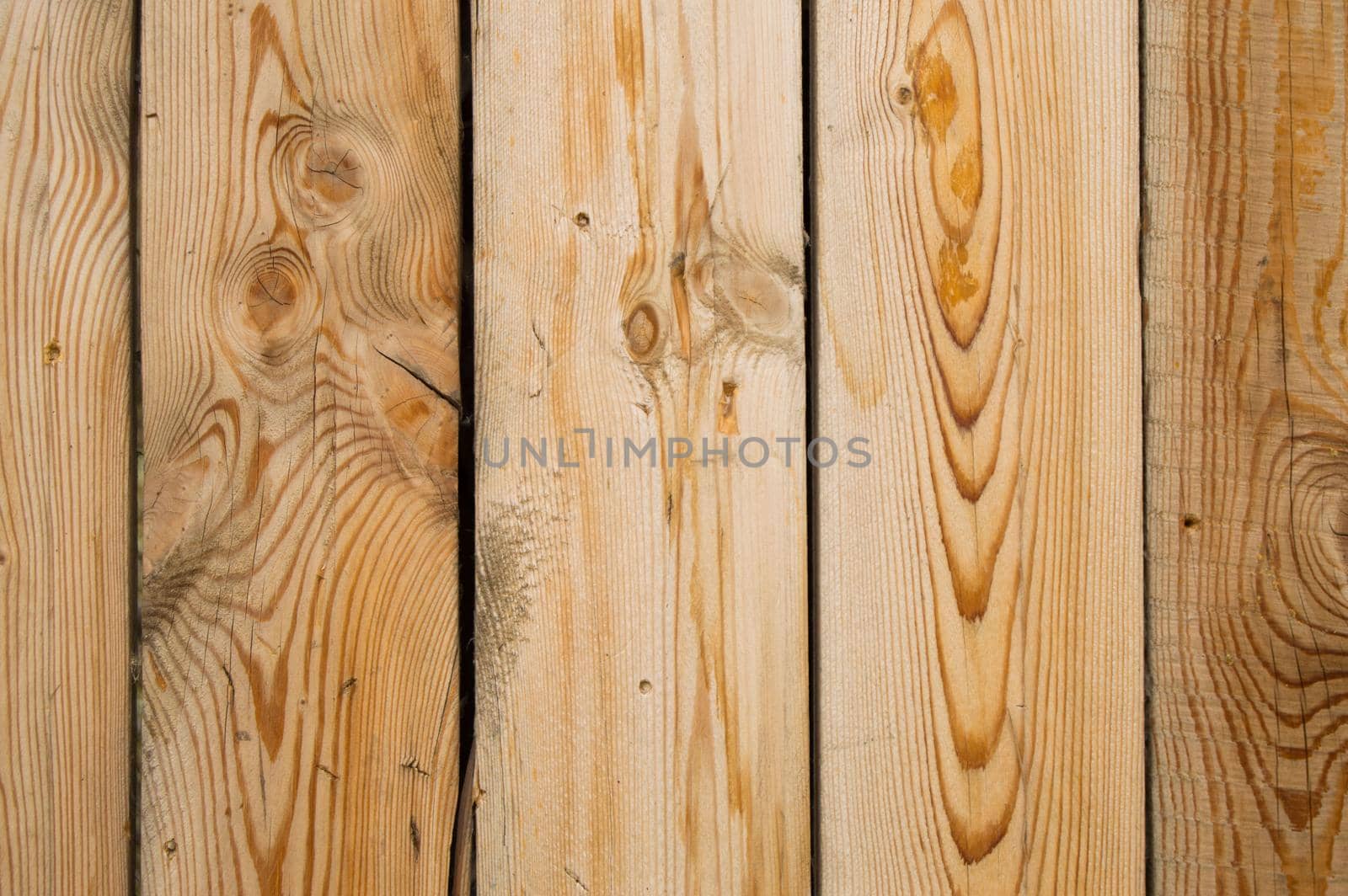 Light wooden planks with cracks, brown texture background.