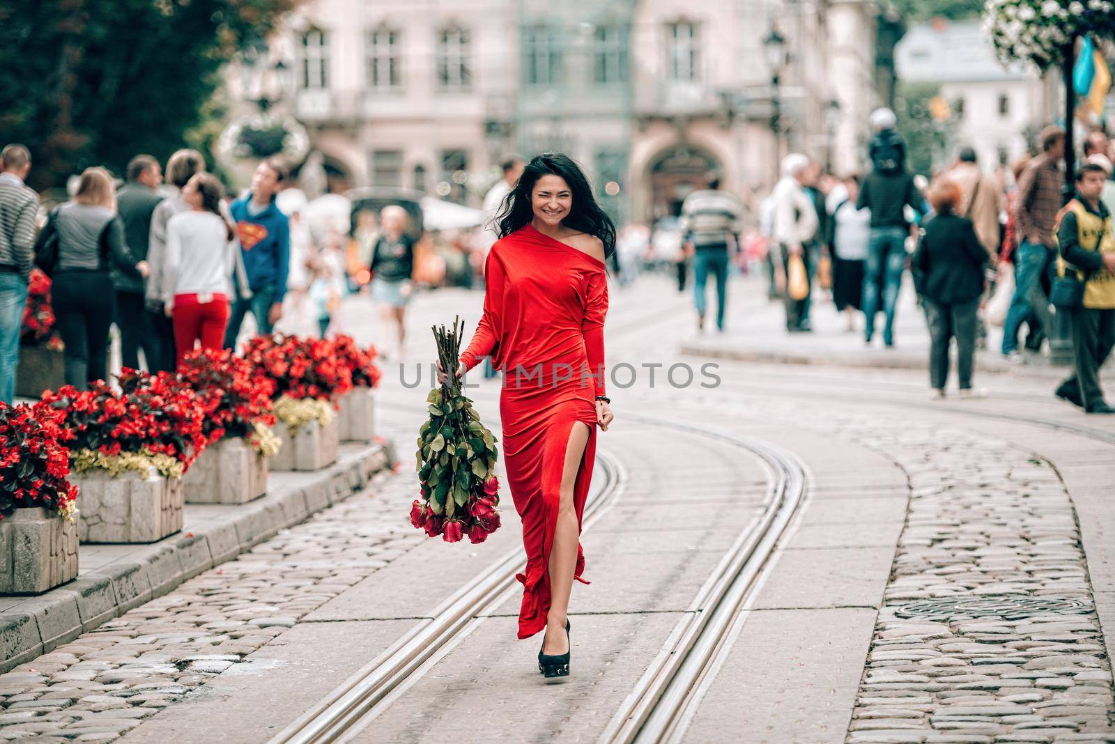 Charming young woman in red sexy dress posing with a bouquet of red roses. . Selective focus, filmgrain by Ashtray25