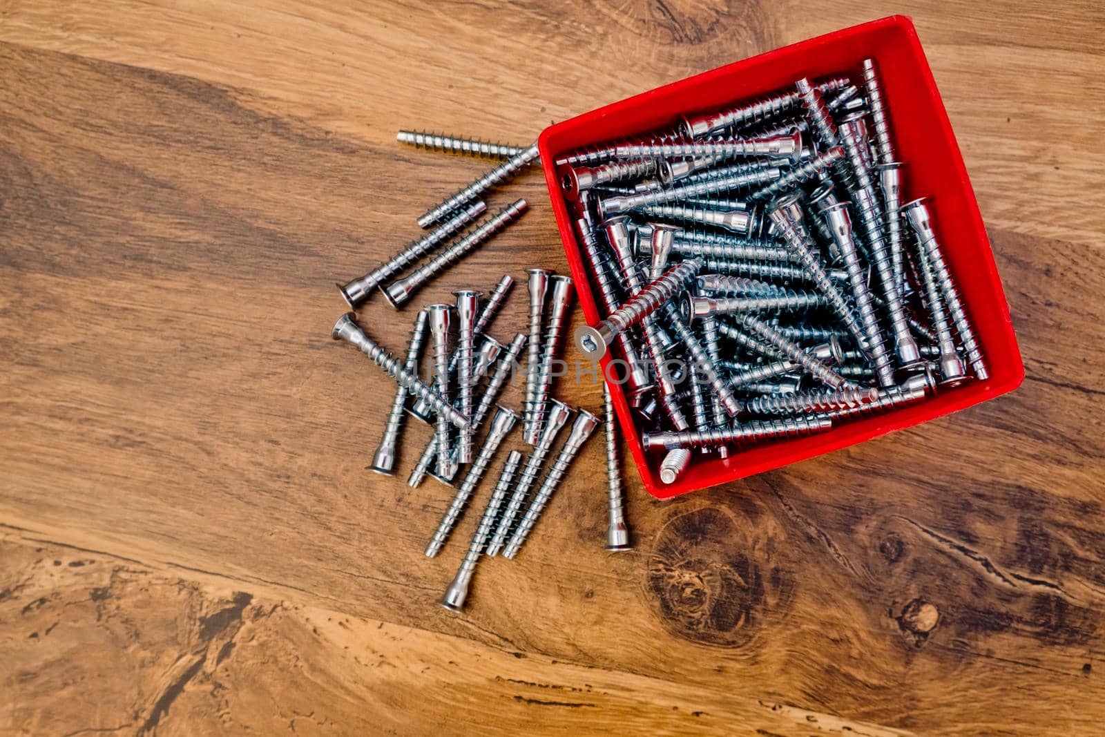 Hex bolts screw for furniture assembly on wooden background. Top view.
