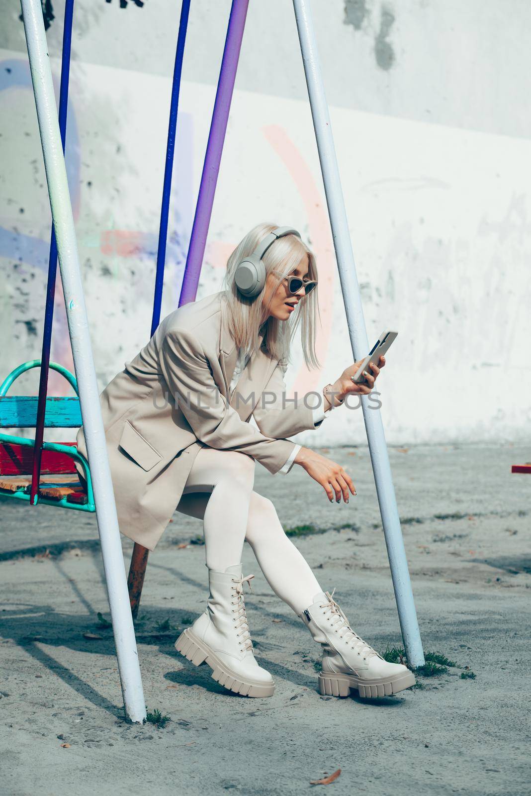 Portrait of blonde woman in headphones listening music with sunglasses. model wear stylish wireless headphones enjoy listen new cool music. by Ashtray25