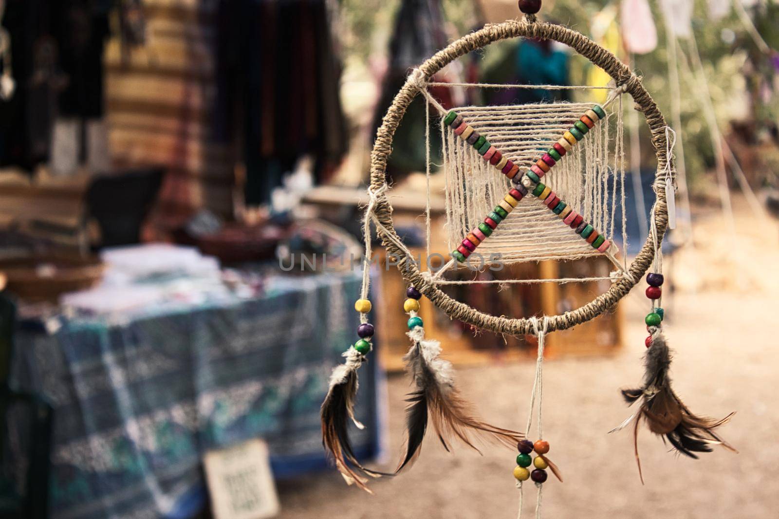 Dream catcher hanging from a tree at a bohemian festival artisan market